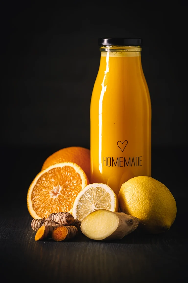 Foodfoto Ingwer-Kurkuma-Shot Flasche und Zutaten