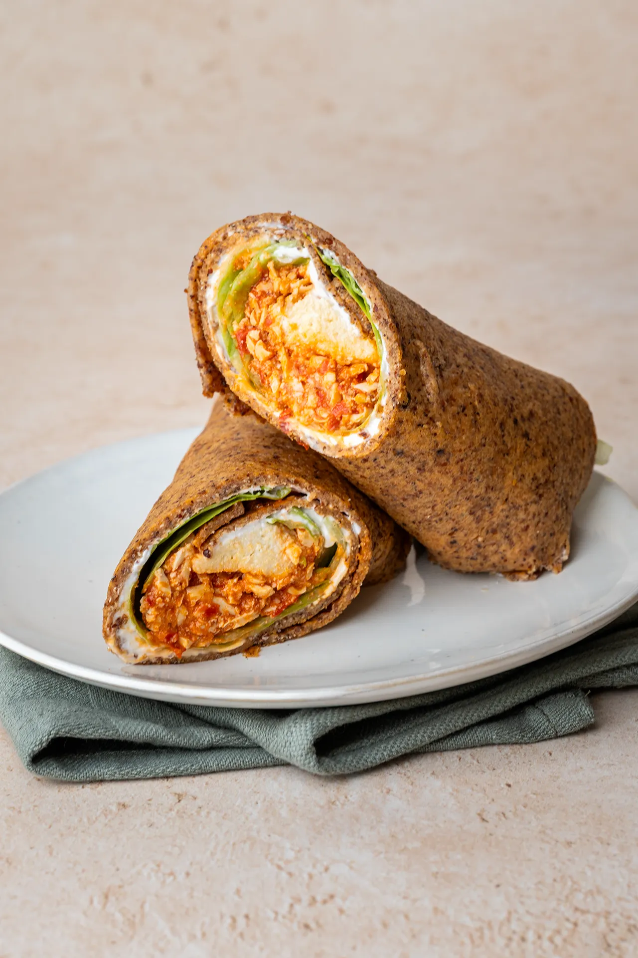 Quinoawrap - glutenfrei und proteinreich 4 gefüllter quinoawrap durchgeschnitten auf einem hellen Teller