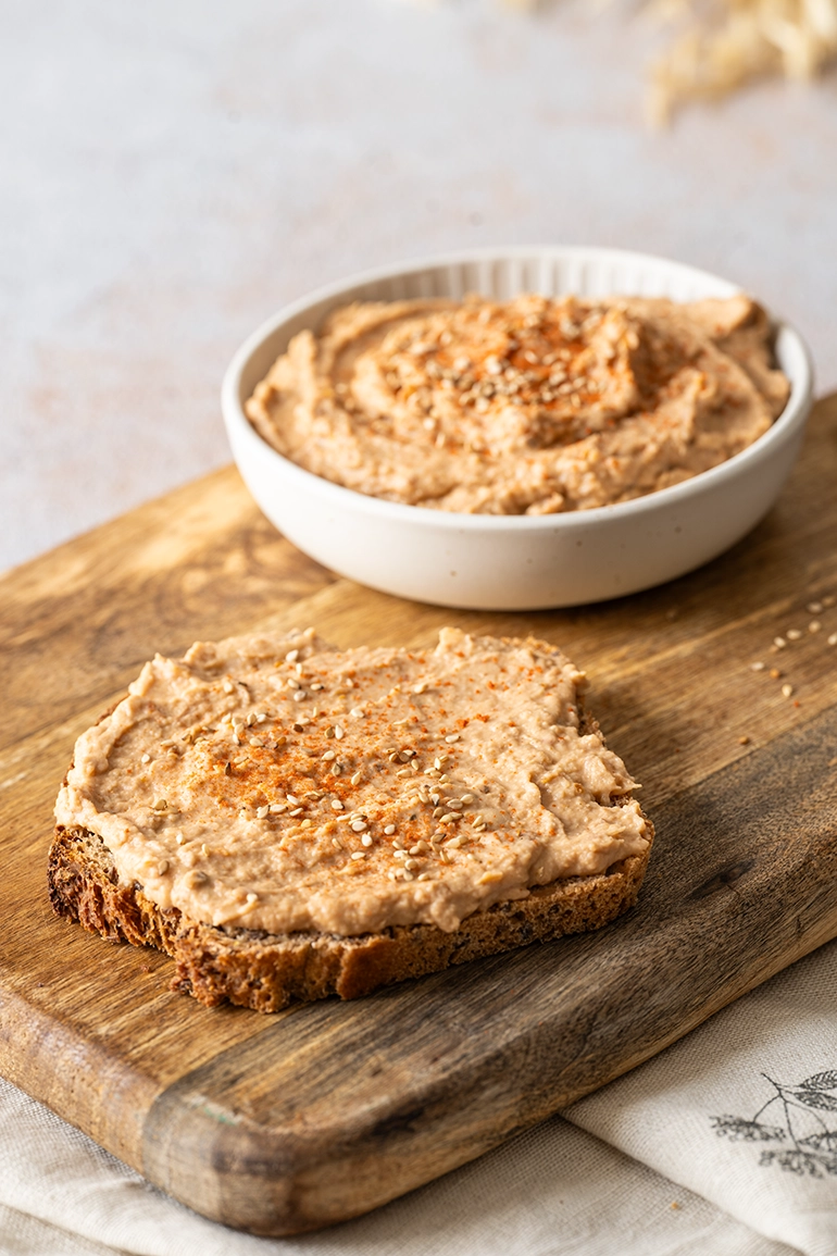 Pikanter Hummus aus weißen Bohnen auf einer Scheibe Brot