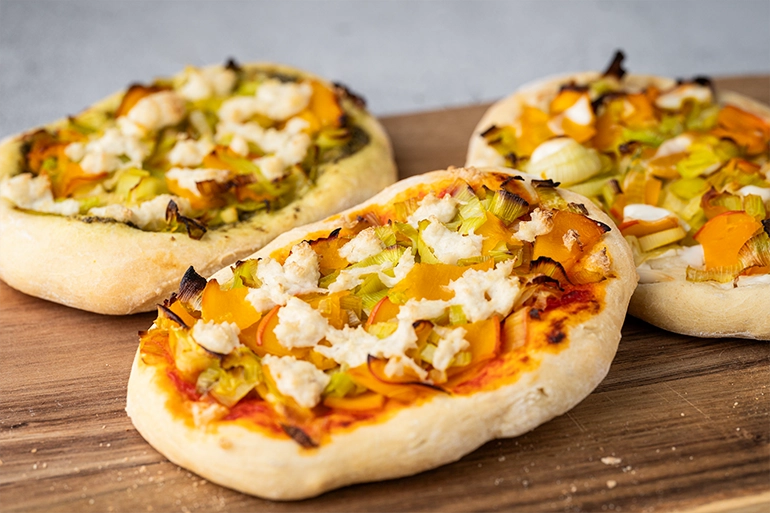 vegane Herbstpizza auf dunklem Brett