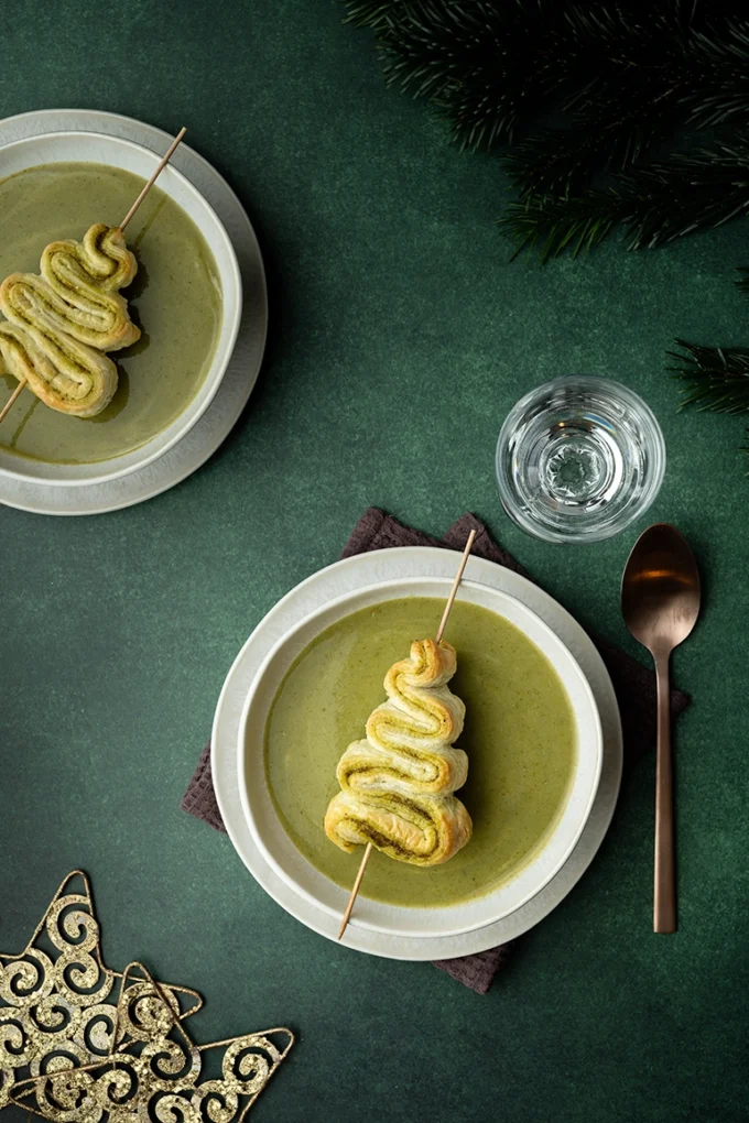 Zwei Schalen mit grüner Suppe und je einem Tannenbaum