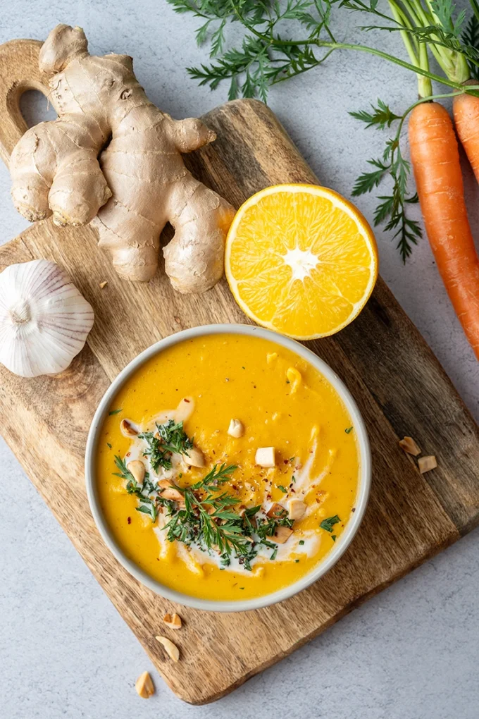 Möhrensuppe mit Ingwer in einer Schale auf einem Brett