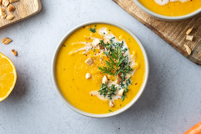 Eine Schale vegane Möhrensuppe mit Ingwer und einem Topping