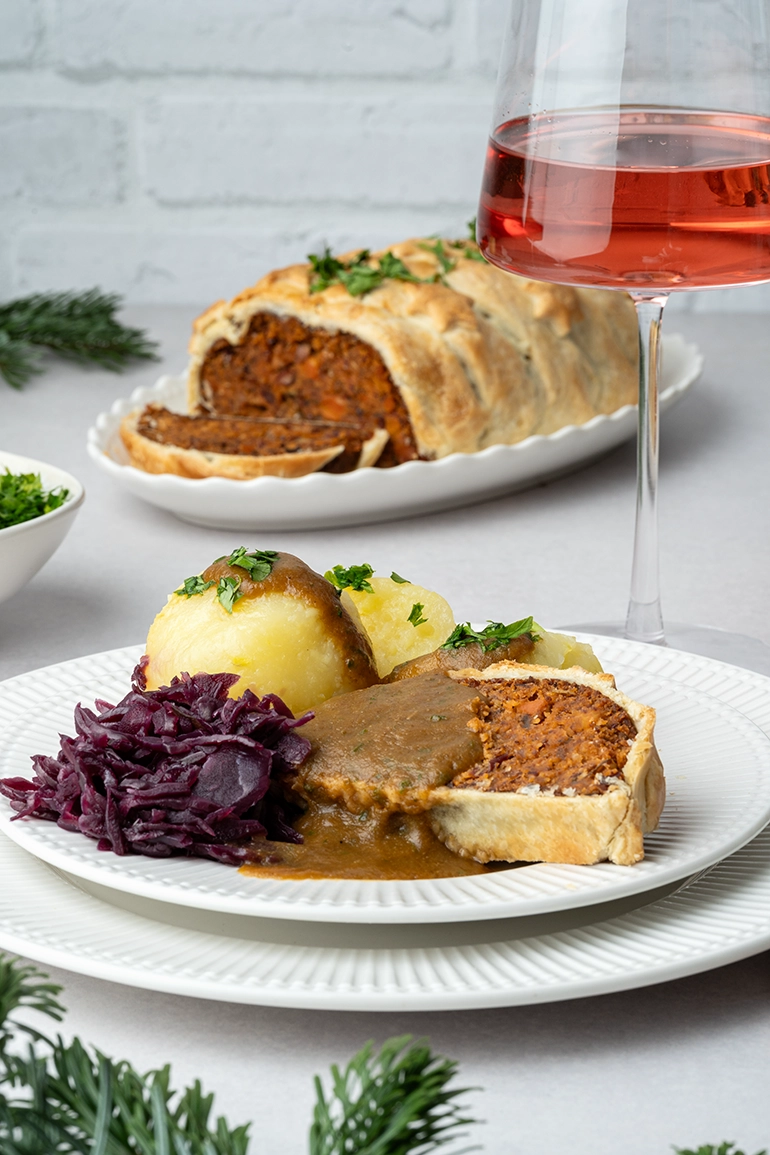 vegan_rezept_Nussbraten_im_Blätterteig_4 Ein Teller mit Nussbraten, Rotkohl, Klößen und brauner Soße