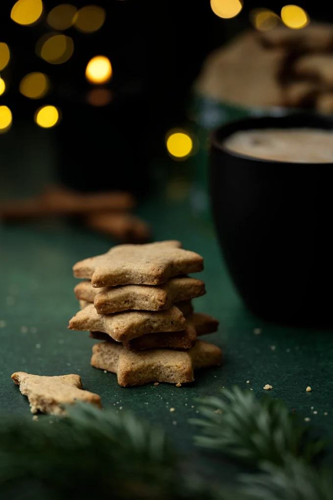 vegane Zimt-Plätzchen neben einer schwarzen Tasse mit Kaffee