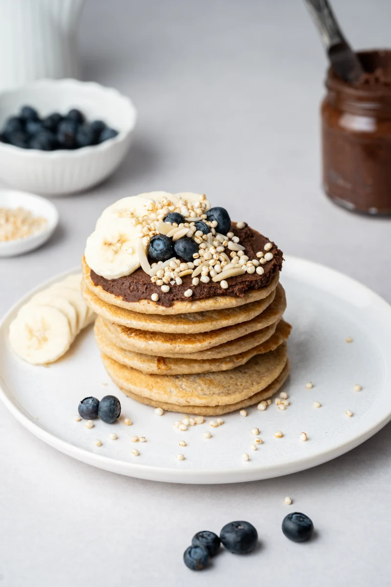 rezept-vegan-schokocreme-vegane-gesunde-pancakes-1 gesunde vegane Pancakes gestapelt mit Schokocreme und Bananenscheiben