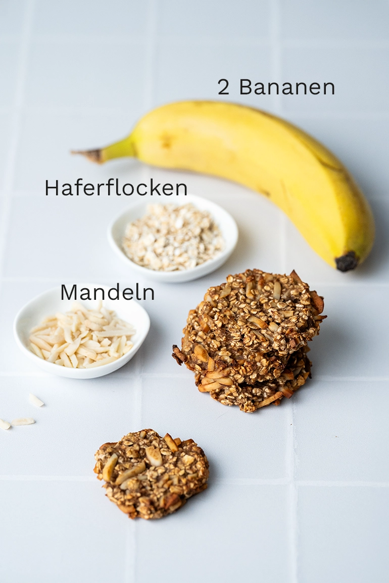 vegan_rezept_zuckerfreie_Kekse_1 Banane, Haferflocken und Mandeln mit Keksen auf hellen Fliesen