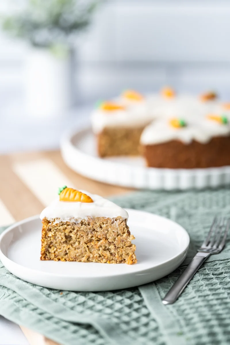 rezept-vegan-ostern-moehrenkuchen-karottenkuchen-2 Ein Stück veganer Karottenkuchen auf einem weißen Teller