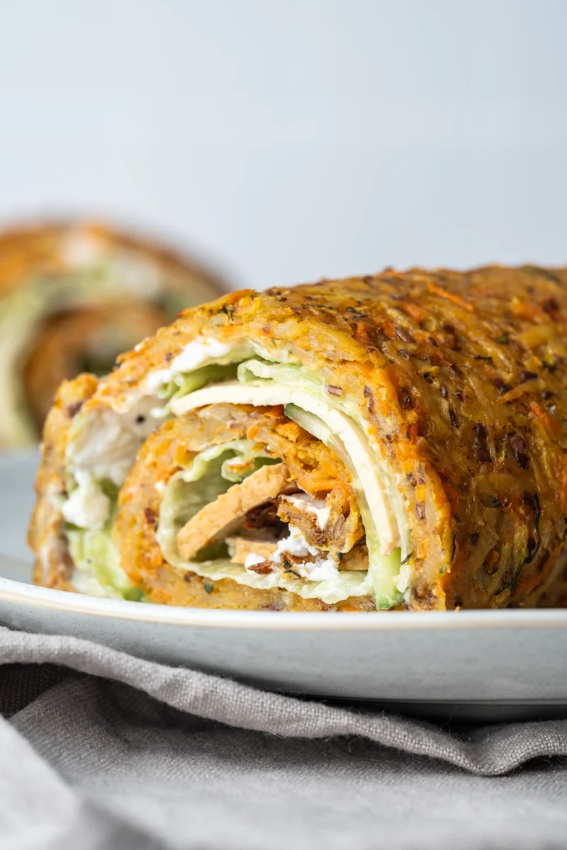 rezept-vegan-kartoffelrolle-gemueserolle Gemüserolle vegan aufgeschnitten auf hellem Teller