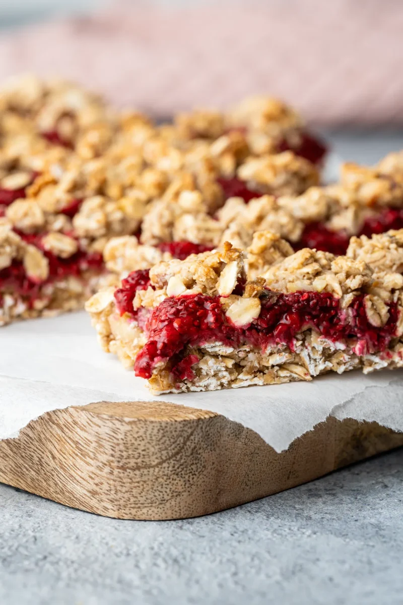 rezept-vegan-Haferriegel-himbeer-nuss-einfach Himbeerschnitten aus Hafer auf einem Brett