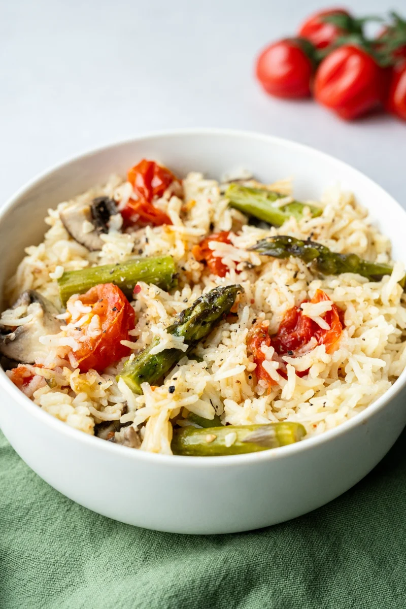 rezept-vegan-ofenreis-spargel-tomaten weiße Schale mit Ofenreis auf grünem Tuch