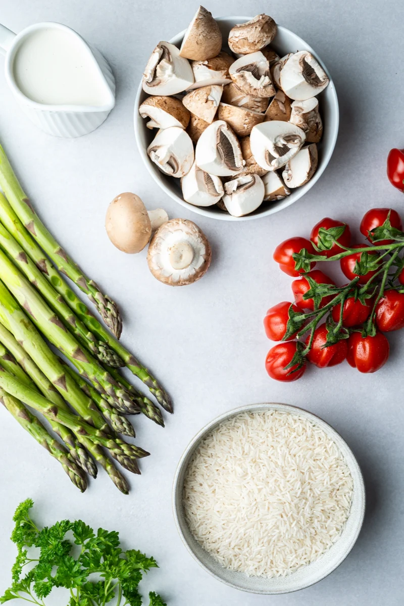 rezept-vegan-ofenreis-spargel-zutaten Zutetan für Ofenreis mit grünem Spargel auf hellem Untergrund