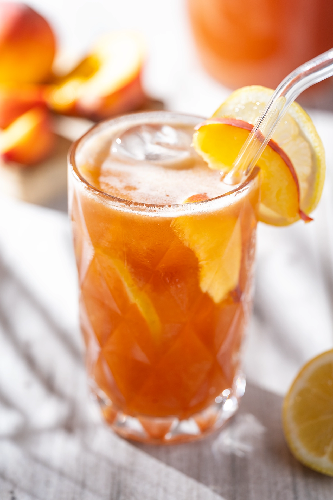 Selbstgemachter Pfirsich-Eistee - zuckerfrei, gesund und lecker 2 Pfirsich-Eistell in gesund un lecker mit Eiswürfeln im Glas