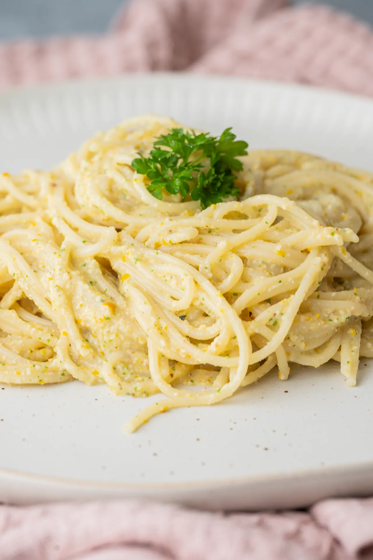 Spaghetti mit cremiger Zucchini Pesto auf einem hellen Teller