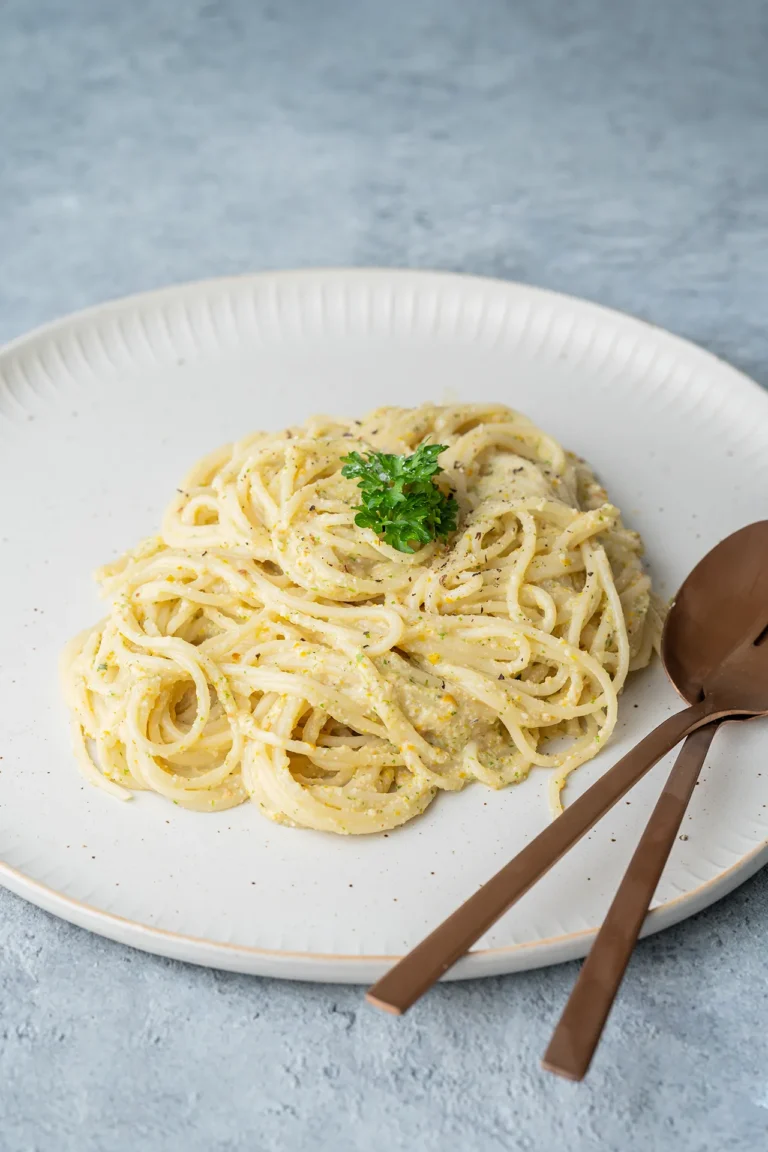 Heller Teller mit Spaghetti mit cremiger Zucchini Pesto aus dem Ofen