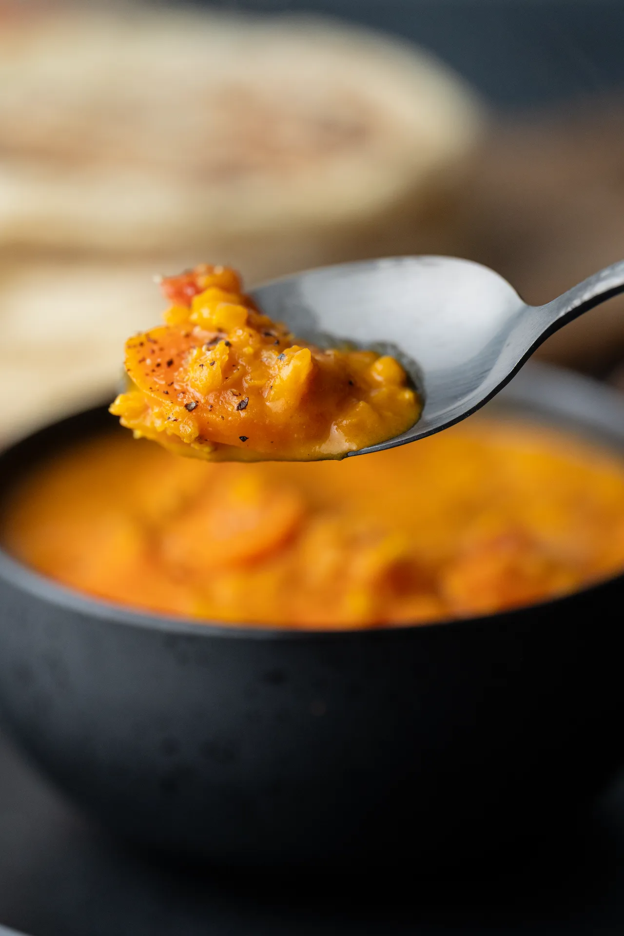 Veganes One-Pot Möhren-Curry mit roten Linsen 2 Ein Löffel mit Möhren-Curry