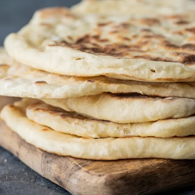 Veganes Naan mit Joghurt gestapelt auf einem Brett
