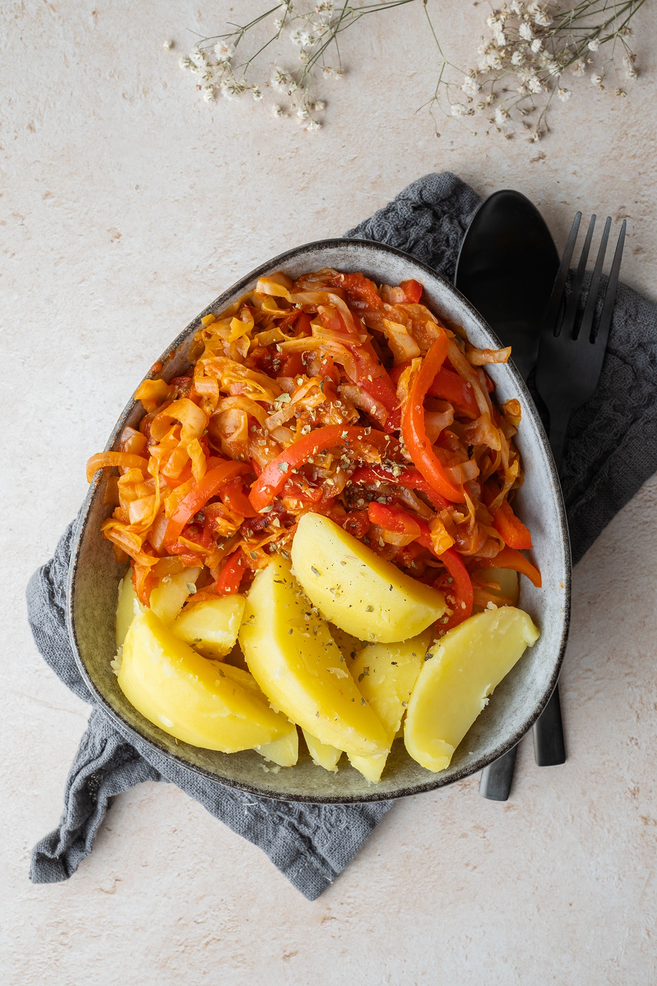 Einfache Spitzkohl-Pfanne mit Paprika 3 eine Schale mit Spitzkohlpfanne und Kartoffen auf einem dunkeln Tuch