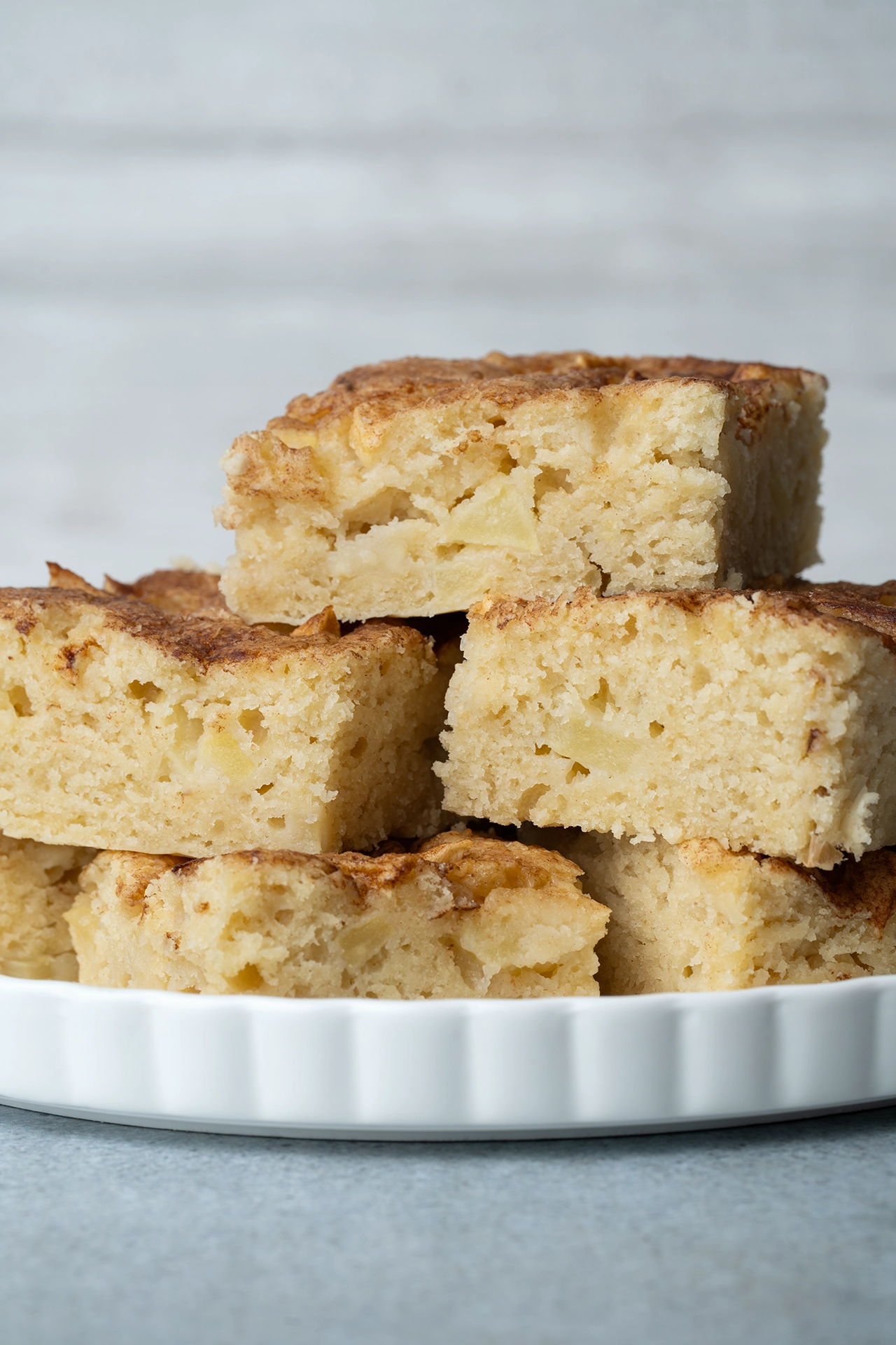 Veganer Apfelkuchen in Stücken gestapelt auf einer weißen Platte