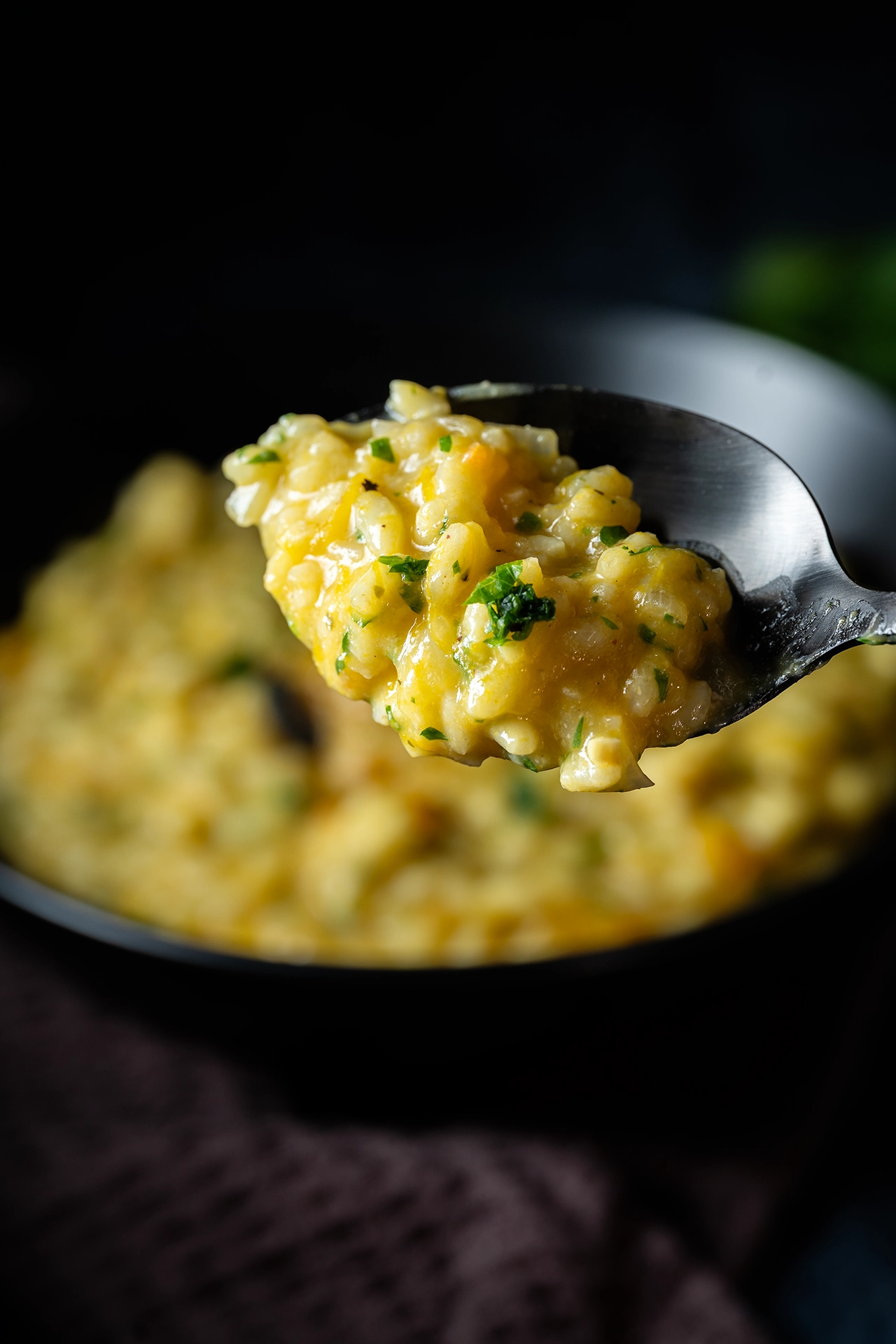 Cremiges Kürbisrisotto 3 Ein Löffel mit Kürbisrisotto und Petersilie
