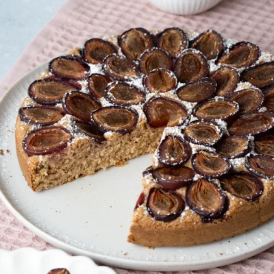 Startseite 17 Gesunder Pflaumenkuchen angeschnitten auf heller Platte