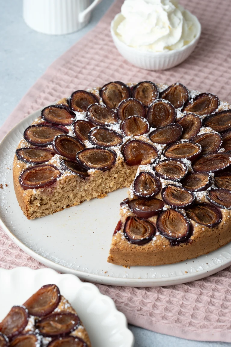rezept-vegan-zwetschgenkuchen-zuckerfrei-glutenfrei Gesunder Pflaumenkuchen angeschnitten auf heller Platte