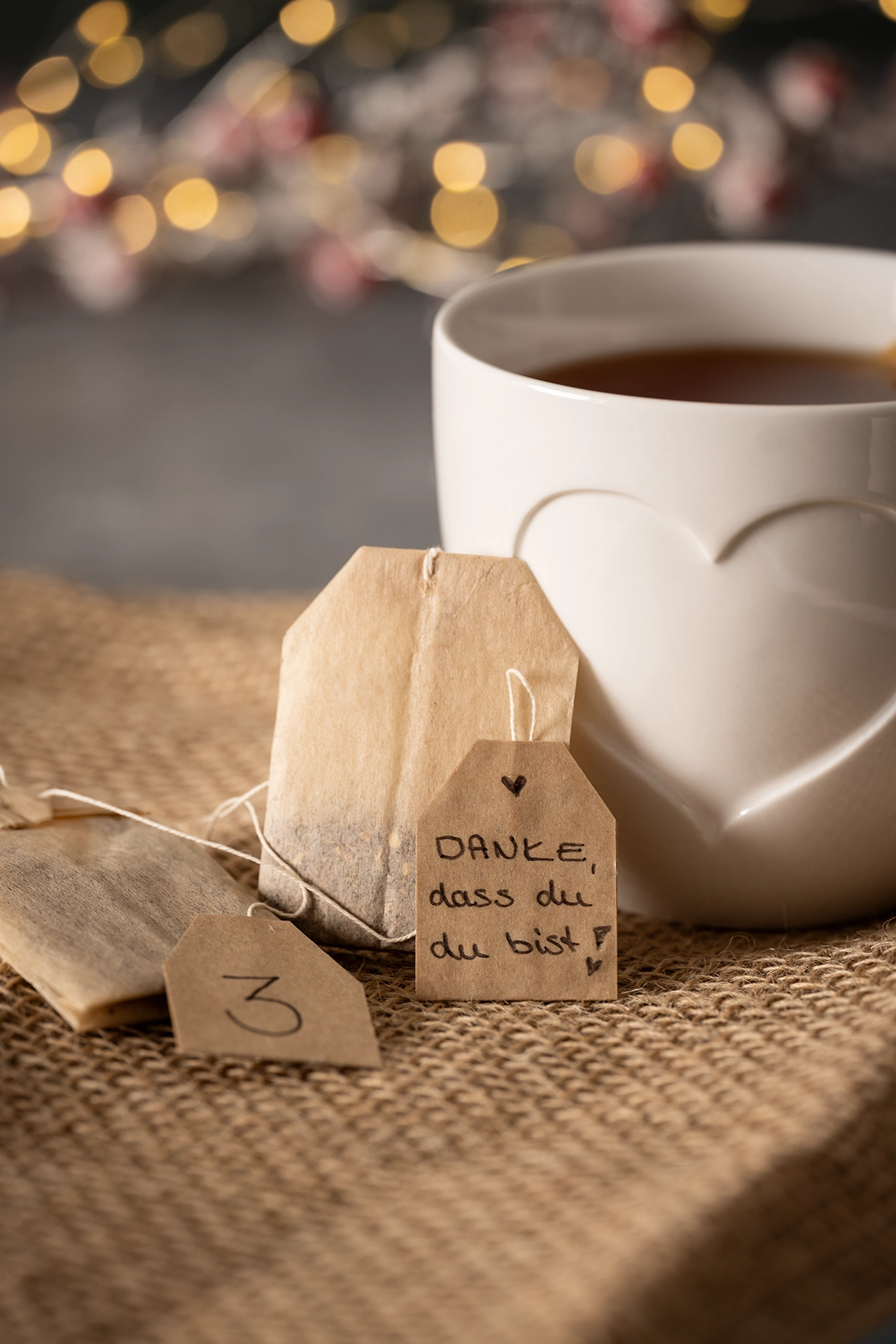 Teetasse mit Teebeutel auf dem ein Kompliment steht