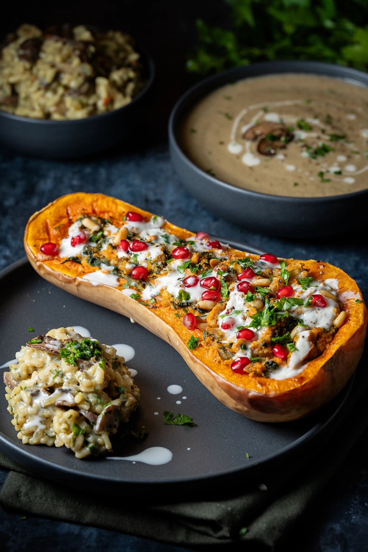 Gefüllter Butternut mit Pilzrisotto auf einem schwarzen Teller