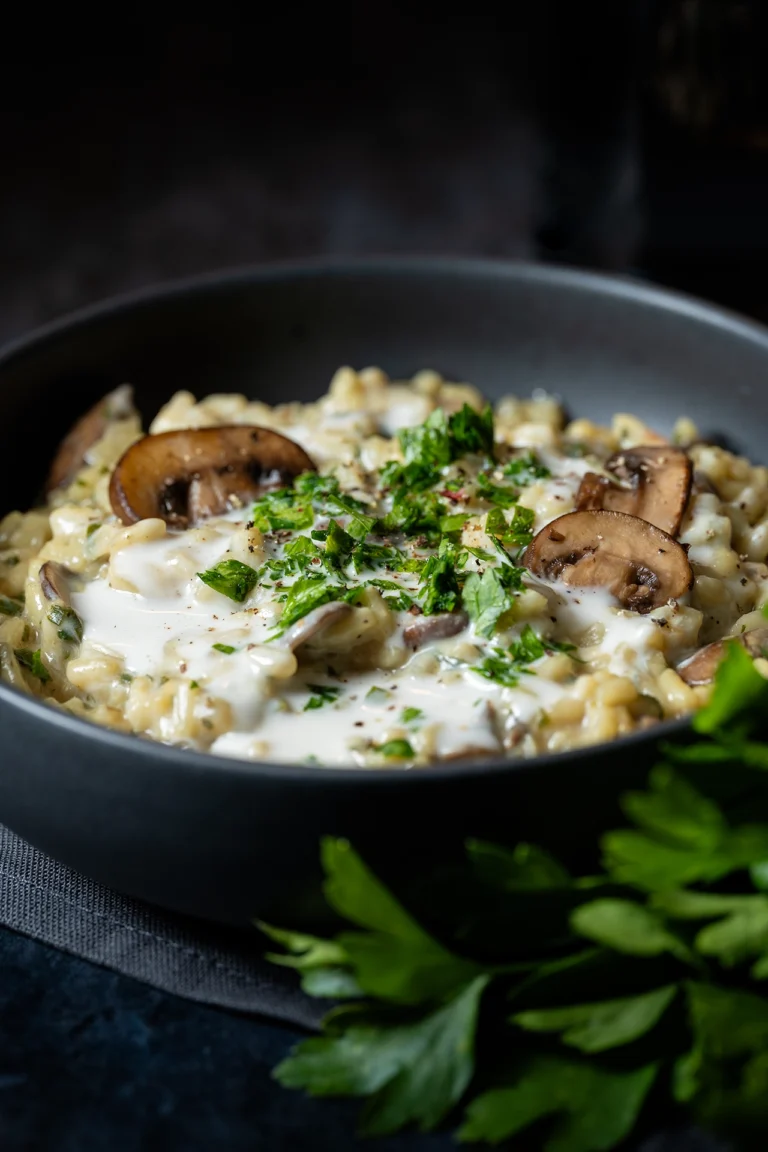 Cremiges veganes Pilzrisotto in schwarzer Schale