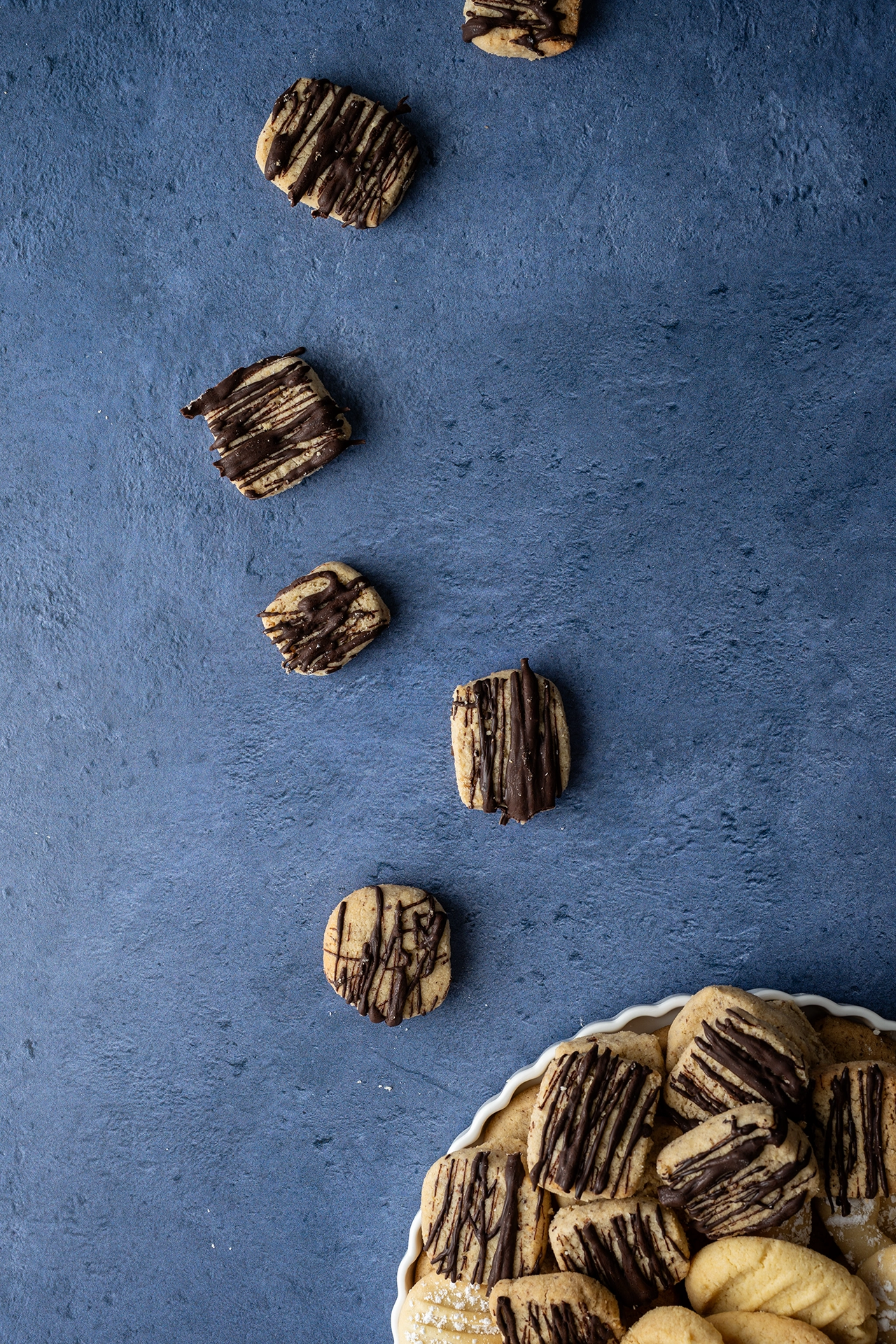 vegane Nussplätzchen mit Schokolade auf blauem Untergrund