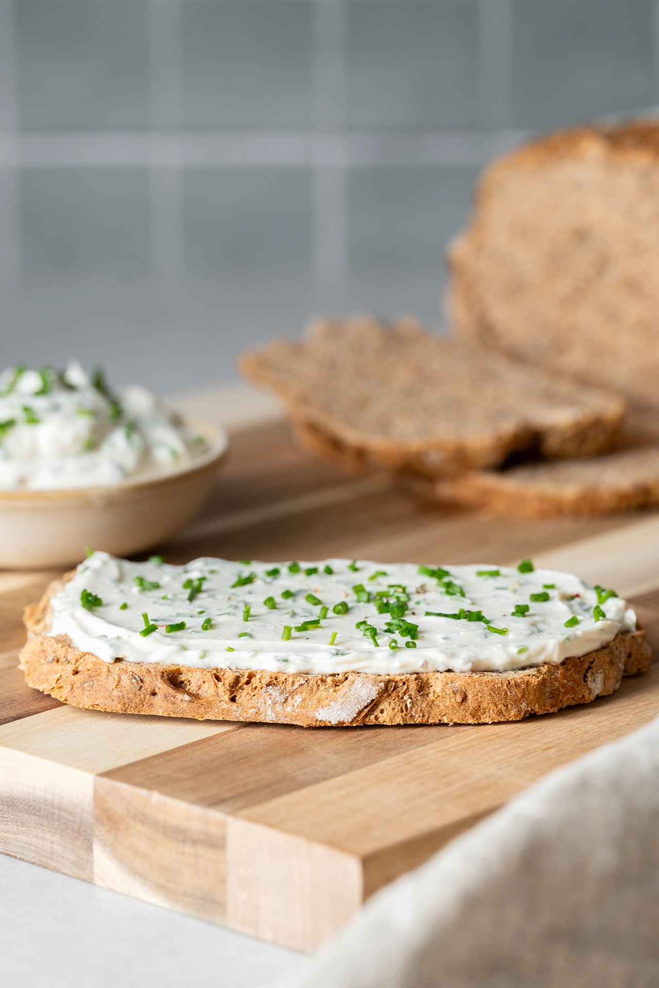 Veganer Kräuterfrischkäse auf einer Scheibe Brot