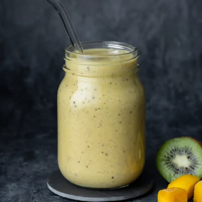 Mango-Kiwi-Smoothie im Glas auf dunklem Untergrund