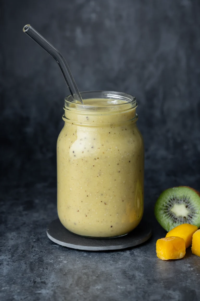 Mango-Kiwi-Smoothie im Glas auf dunklem Untergrund