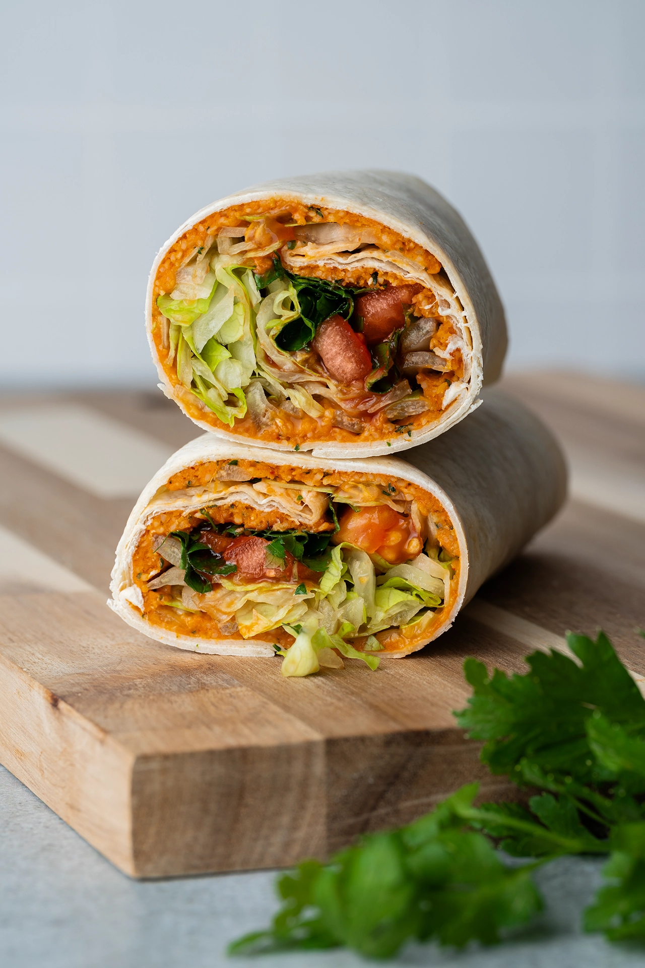 Cigköfte-Wrap halbiert und aufeinander gelegt auf einem Brett