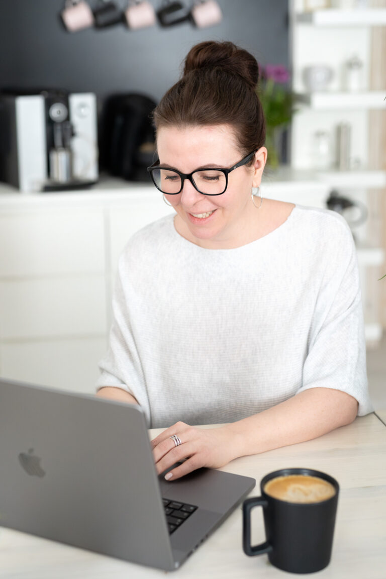 Katja am Laptop daneben eine Tasse Kaffee