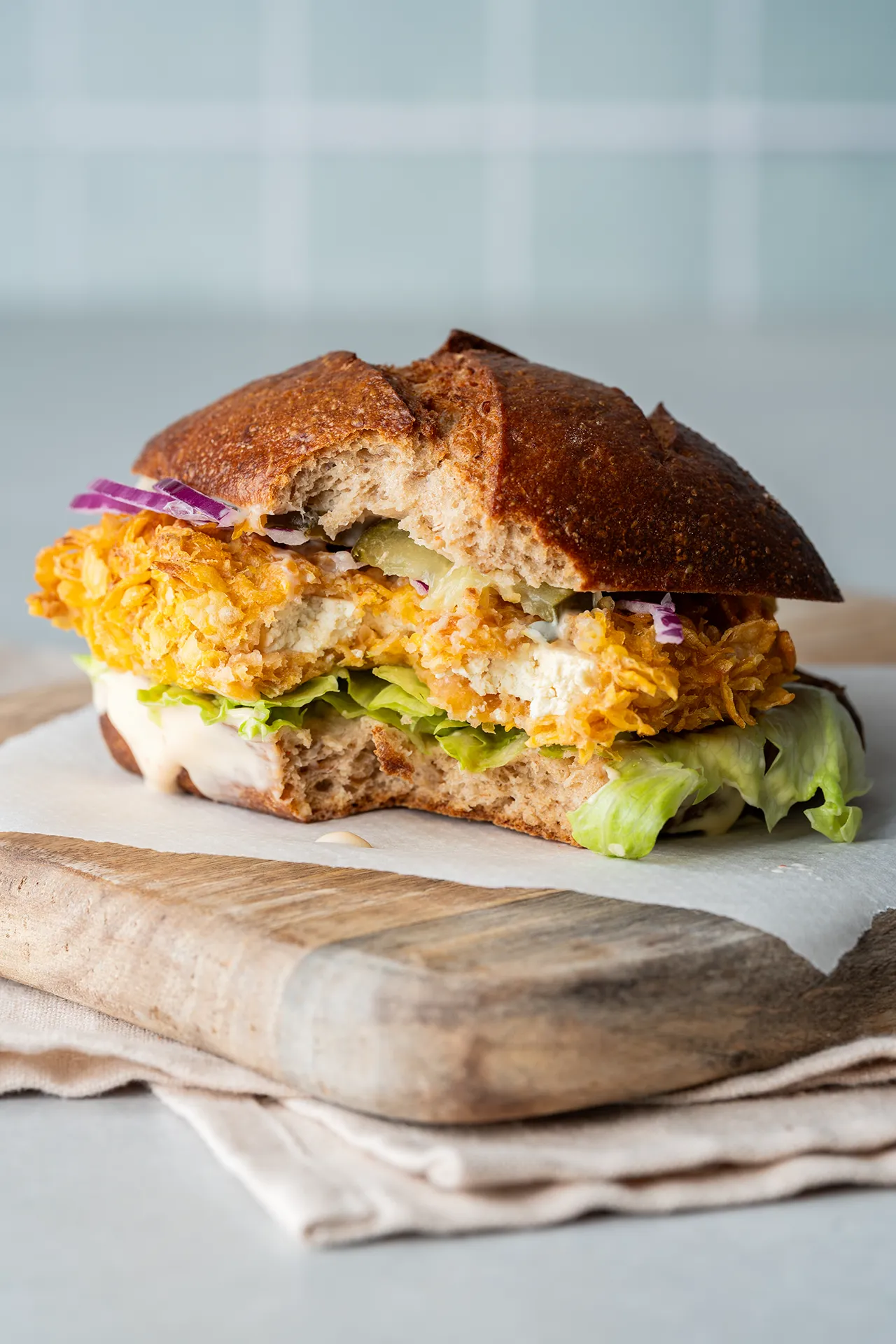 Crispy Tofu Sandwich – knusprig, würzig und richtig sättigend 2 Brötchen mit crunchy Tofu auf einem Brett