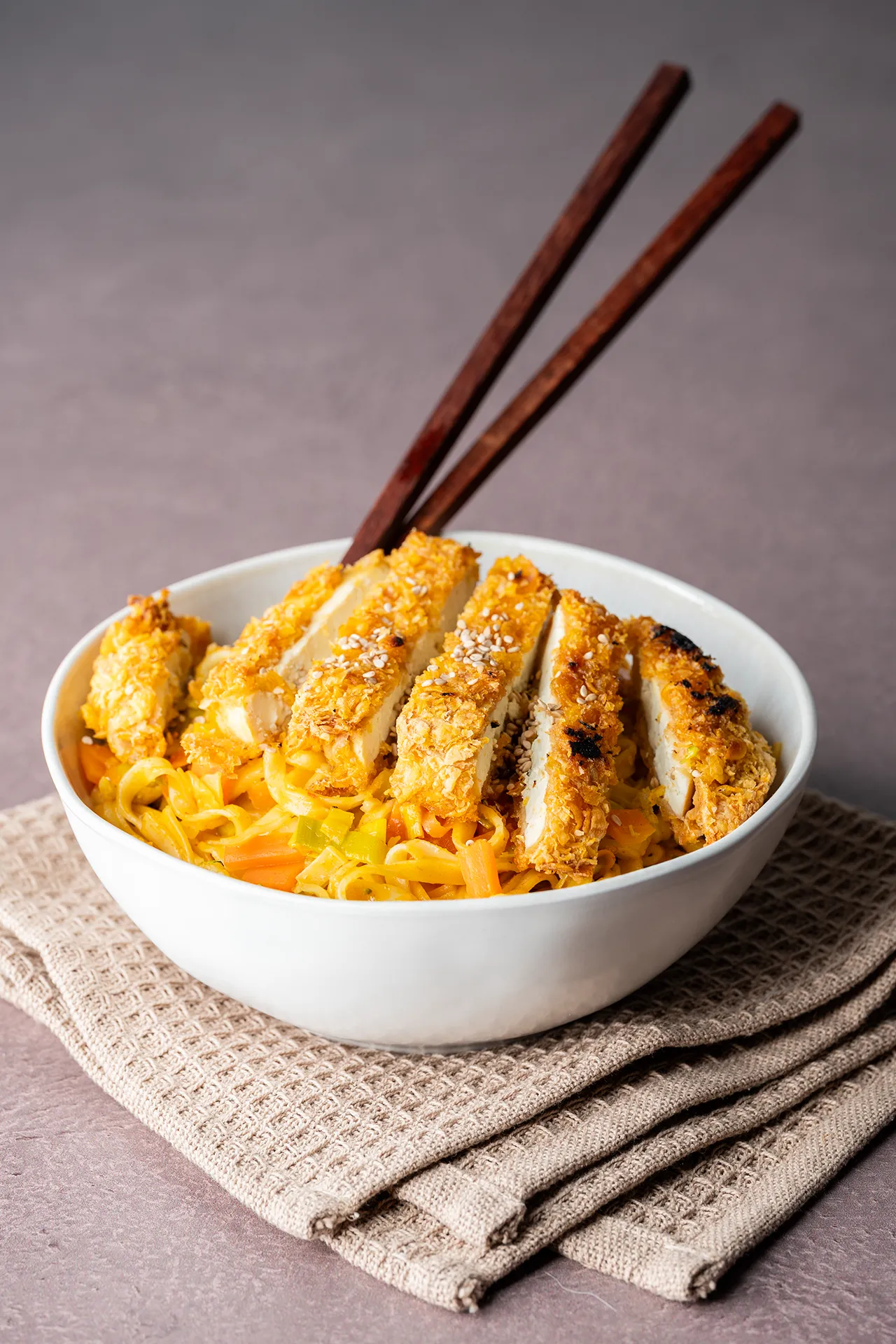 Crispy Tofu Sandwich – knusprig, würzig und richtig sättigend 3 Crispy Tofu auf einem asiatischen Nudelgericht mit braunen Stäbchen