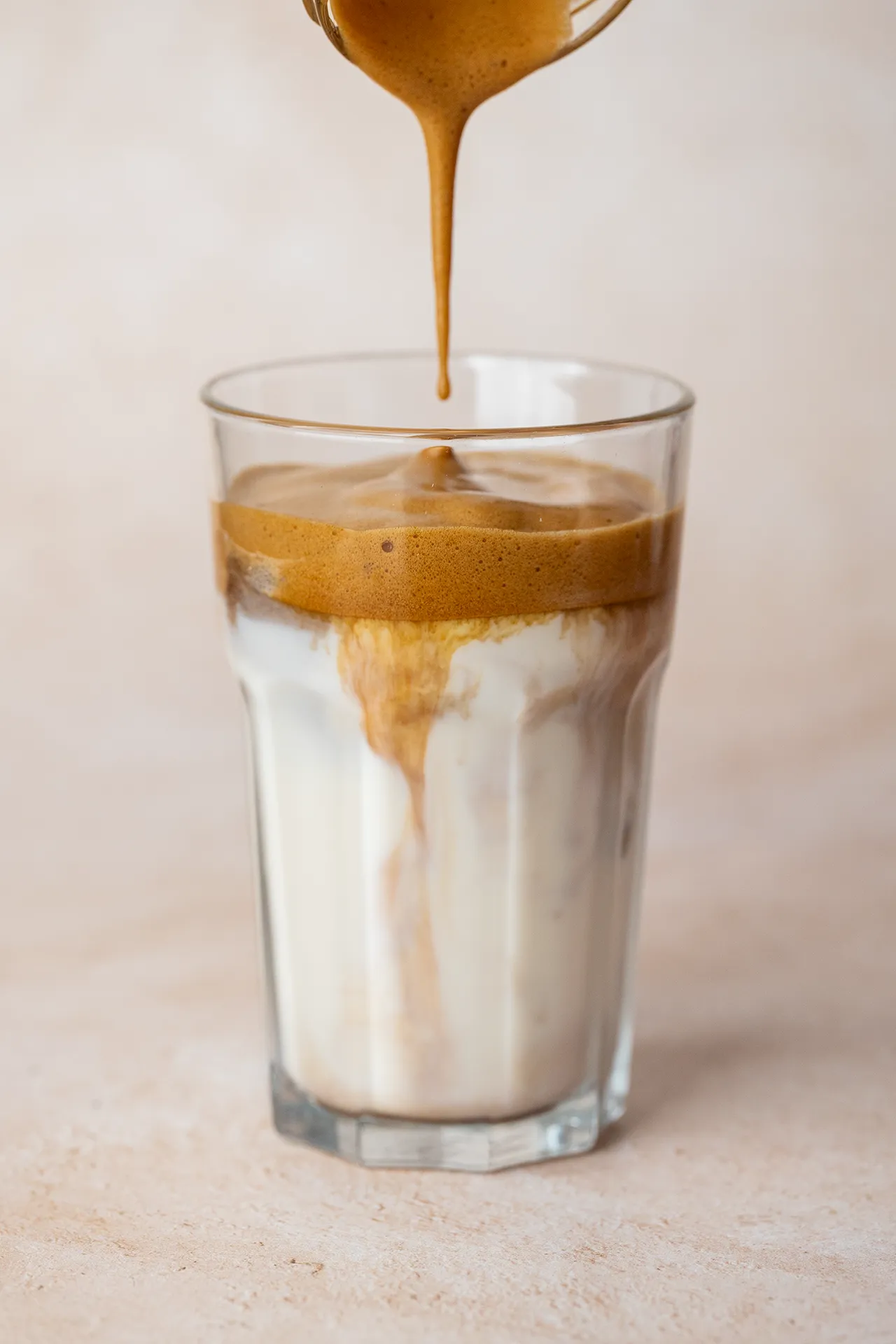 Eiskaffee mit Instantkaffee – einfaches Rezept in 2 Minuten 2 Einfacher Eiskaffee mit Instatkaffee in einem Glas beim Eingießen