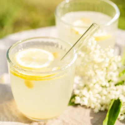 Zuckerfreie Holunderblüten-Limo in einem Glas mit Trinkhalm