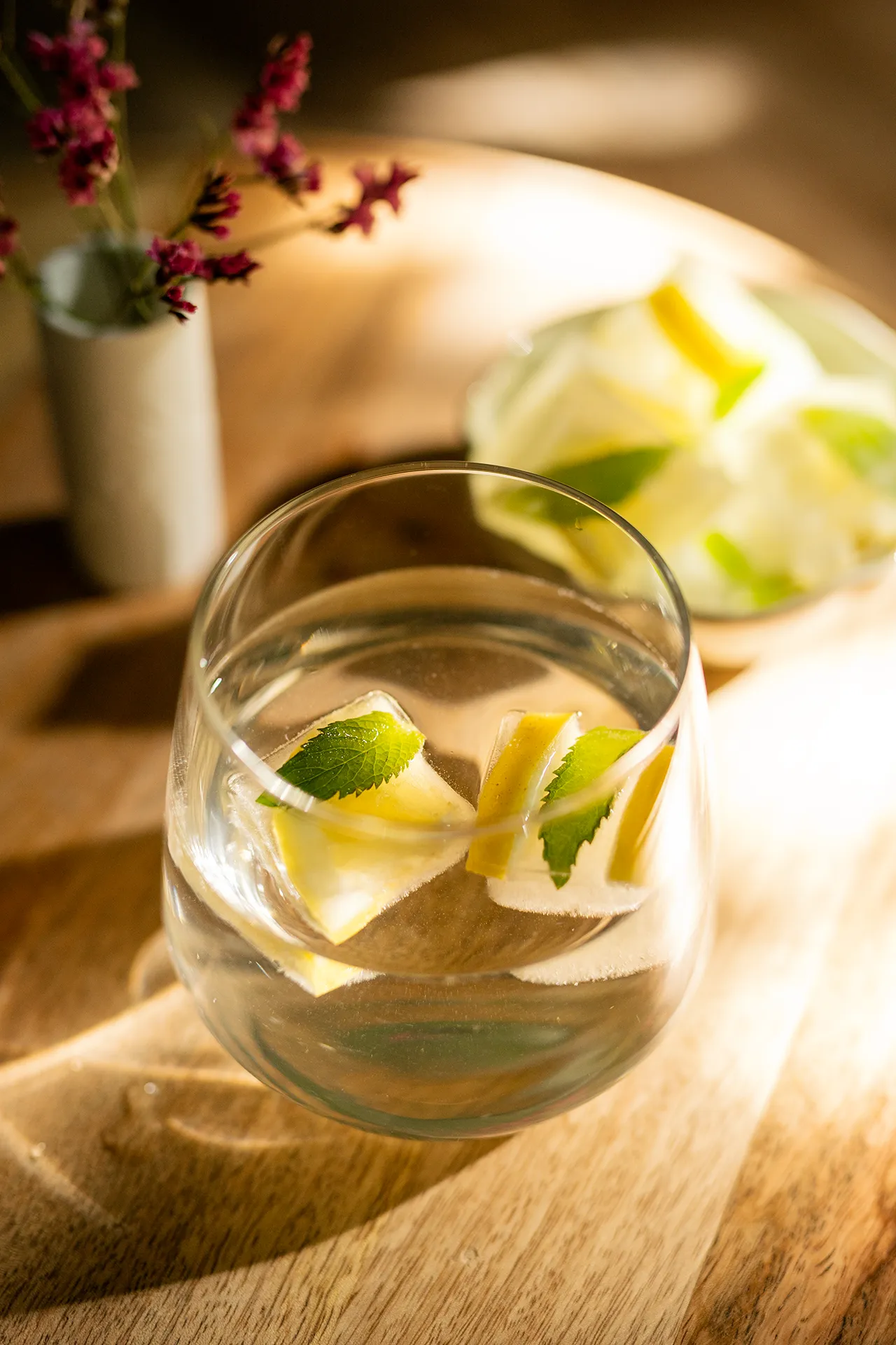 Infused Water mit Zitrone und Minze in einem Glas auf einem Holztisch
