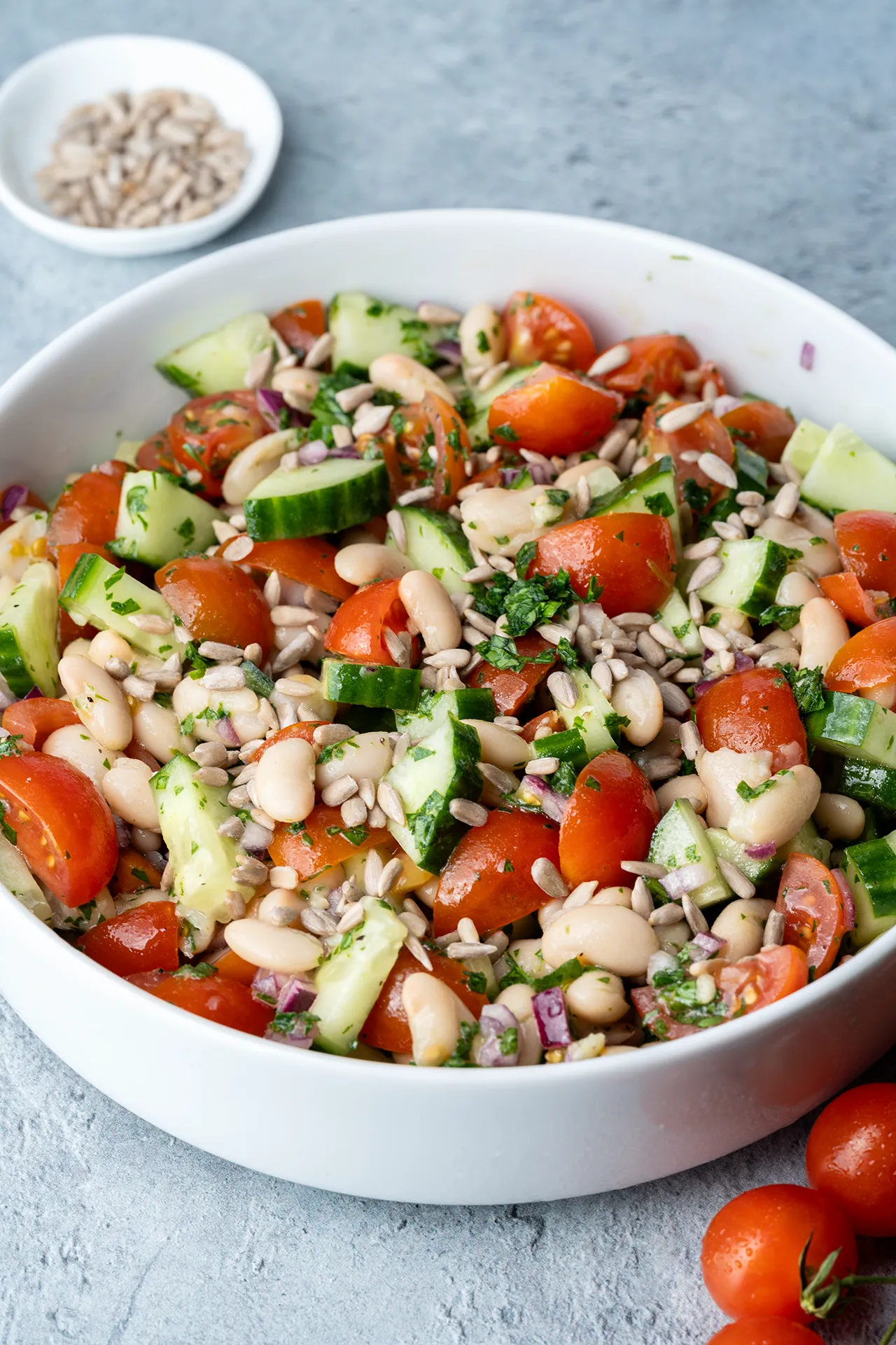 Weißer-Bohnen-Salat mit Sonnenblumenkerne getoppt in einer weißen Schale