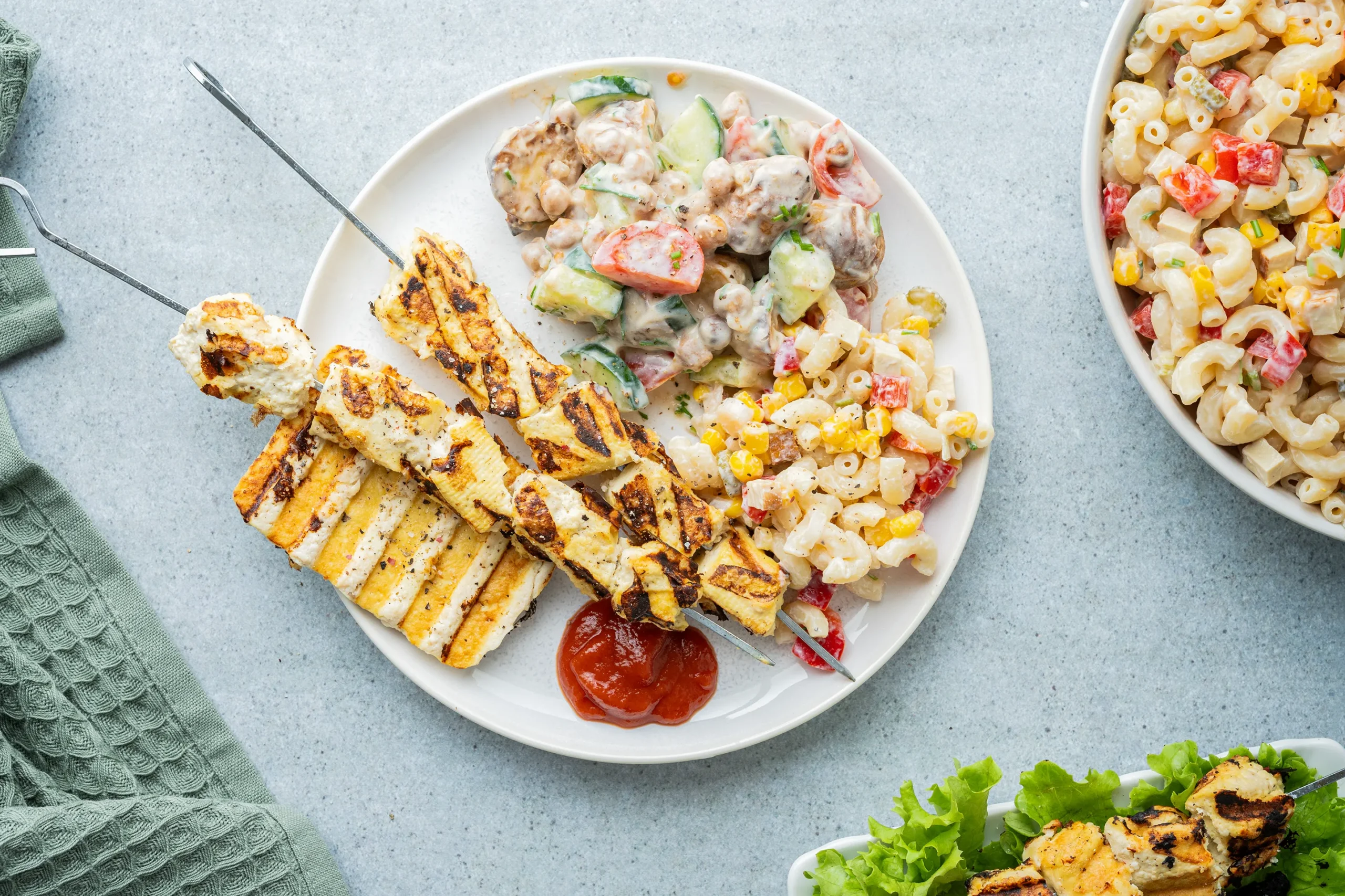 Veganer Grillteller mit Spießen, Tofu und Salat