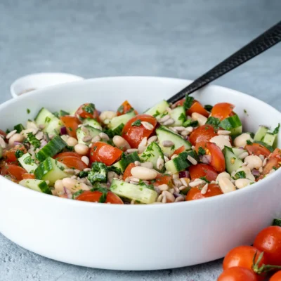Weißer Bohnen Salat mit Tomaten und Gurke in weißer Schale