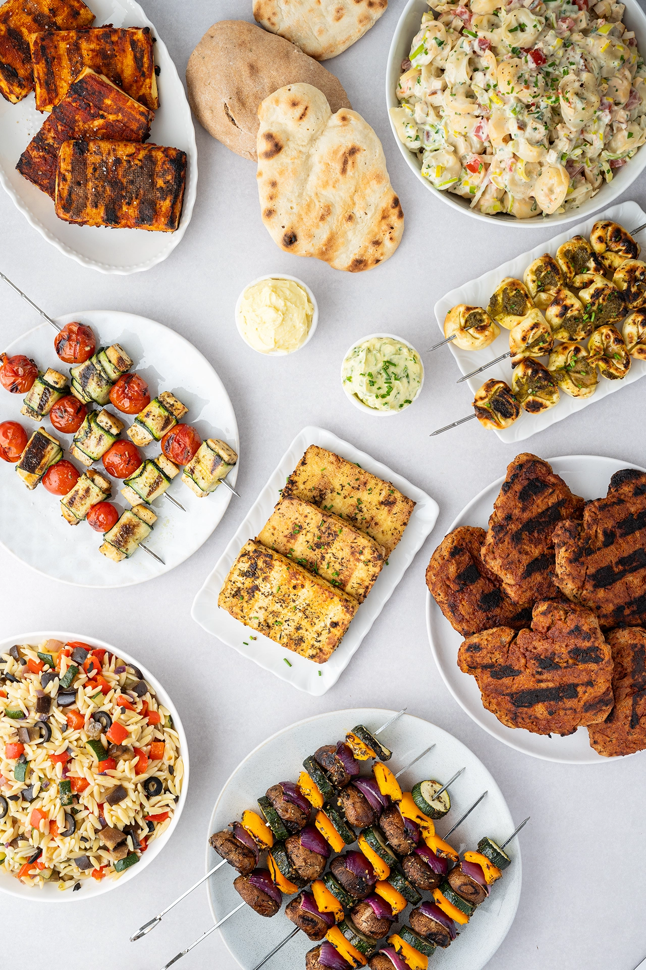 Vegane Grillrezepte auf einem Tisch mit verschiedenen Salaten und Grillgut