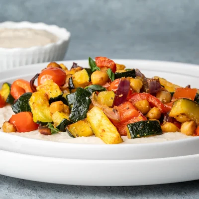 Zucchini vom Blech mit Kichererbsen und Bohnencreme auf einem weißen Teller