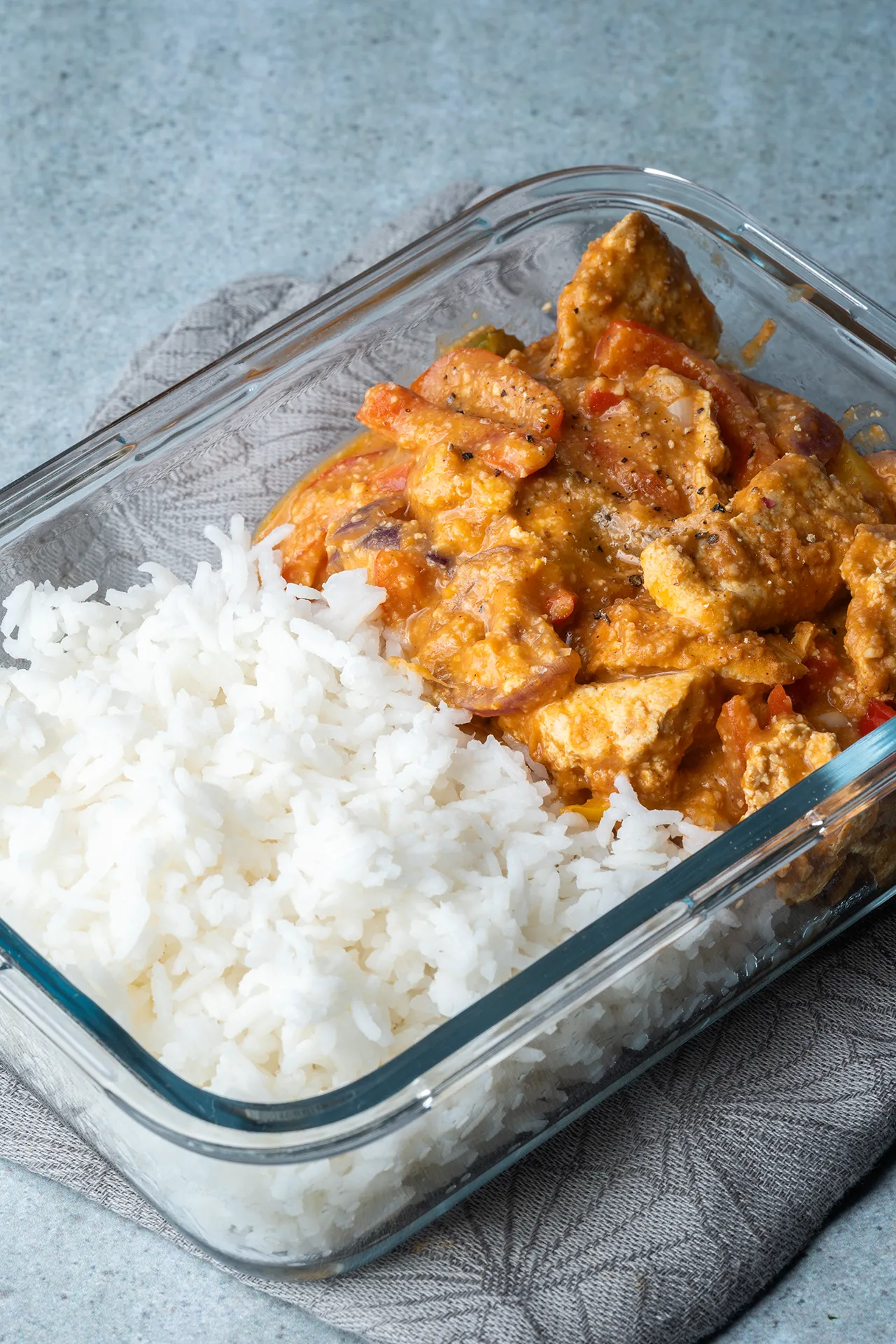 Veganes Paprika-Sahne-Hähnchen mit Tofu – ganz ohne Sahne 1 Eine Glasschale mit Reis und der veganen Paprika-Sahne-Hähnchen-Soße